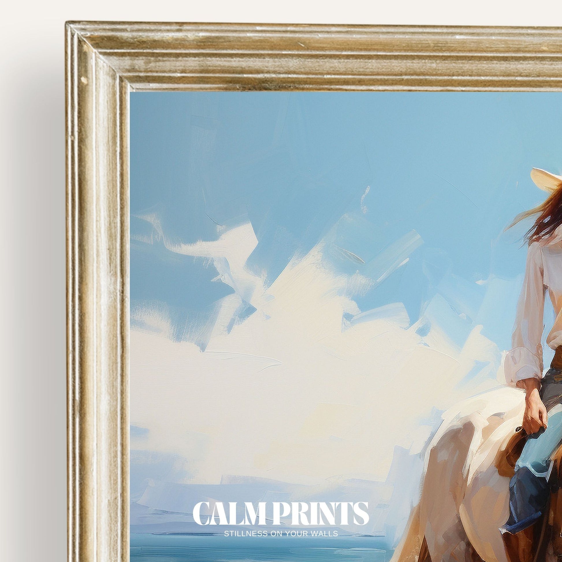 Print of a cowgirl on horseback riding peacefully by the sea in summer light
