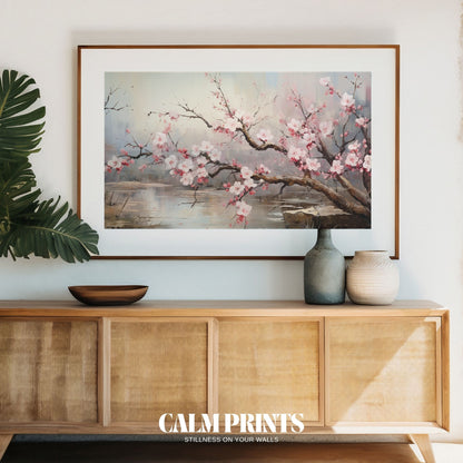 Cherry blossom branches stretching over a quiet lake in springtime
