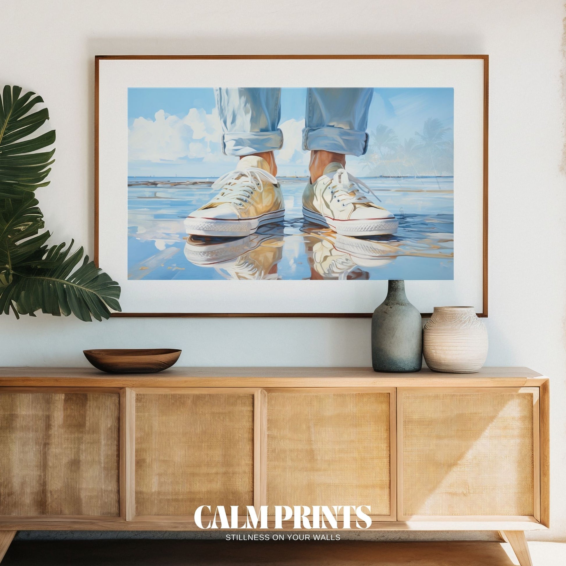 Print of relaxed sneakers at the edge of a warm, sunlit beach
