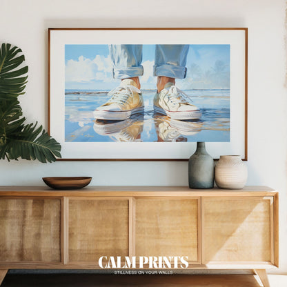 Print of relaxed sneakers at the edge of a warm, sunlit beach
