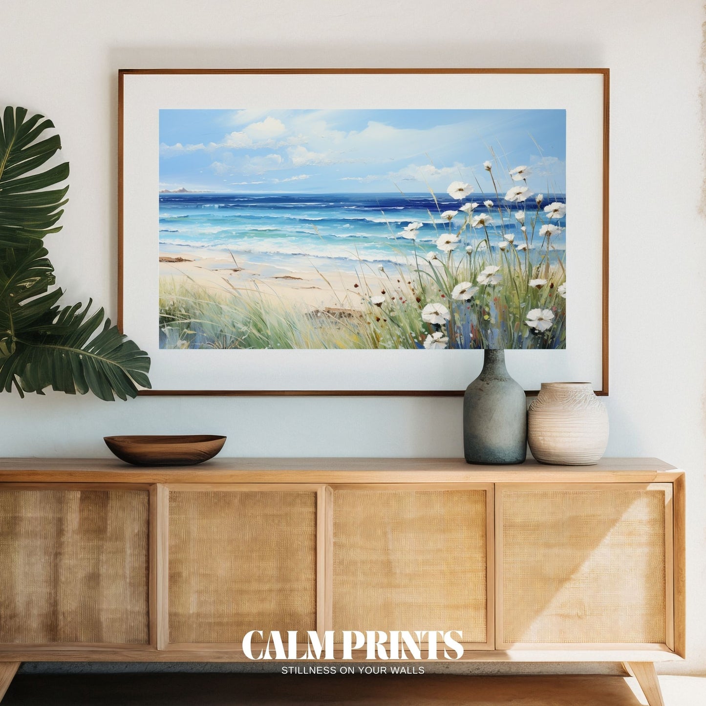 Ocean view framed by soft white coastal flowers under a clear sky
