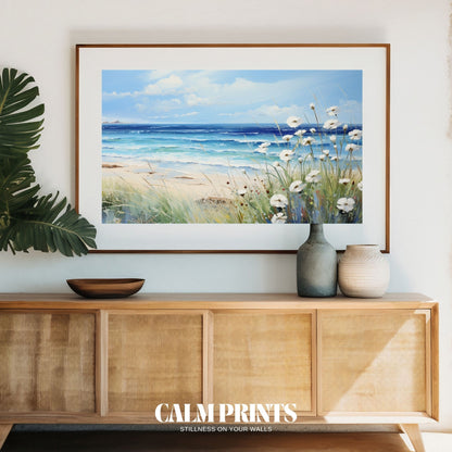 Ocean view framed by soft white coastal flowers under a clear sky
