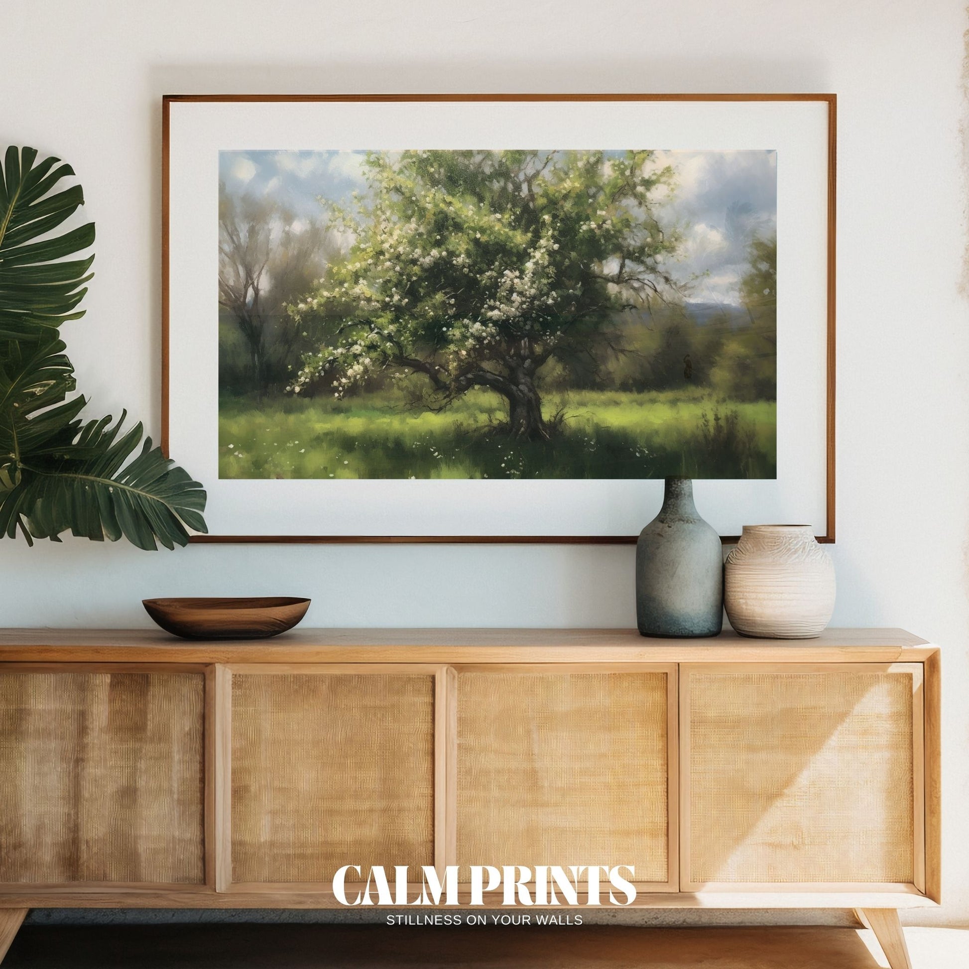 Pastel-toned tree in bloom on a gentle hillside in spring
